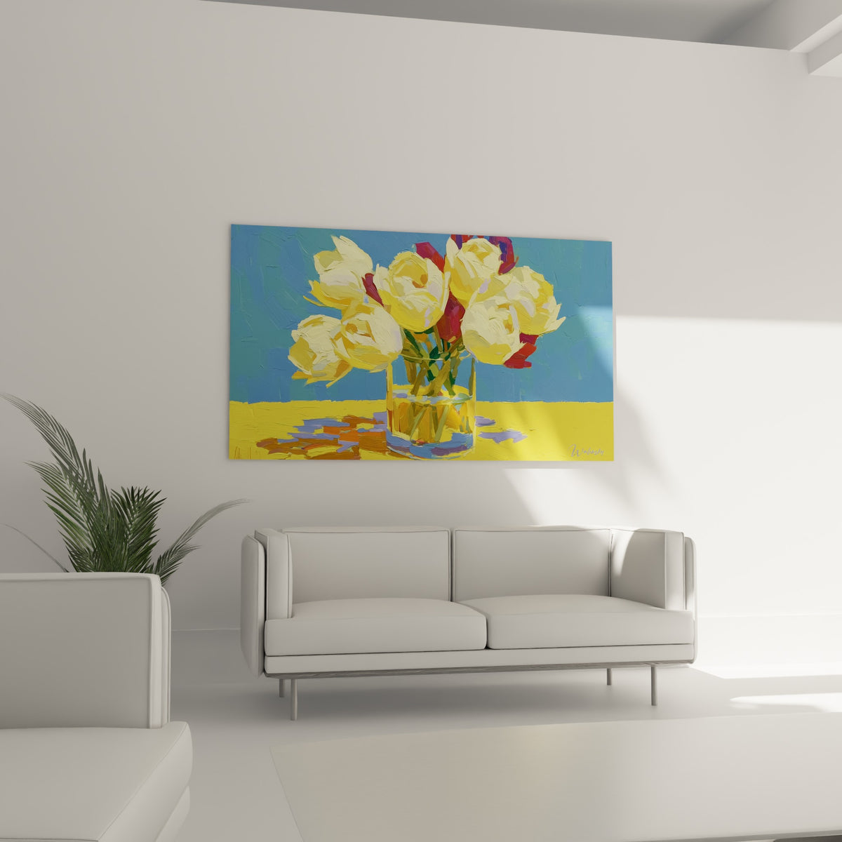 Vase transparent débordant de tulipes crème et rouge bordeaux, au-dessus d'un canapé dans un salon lumineux