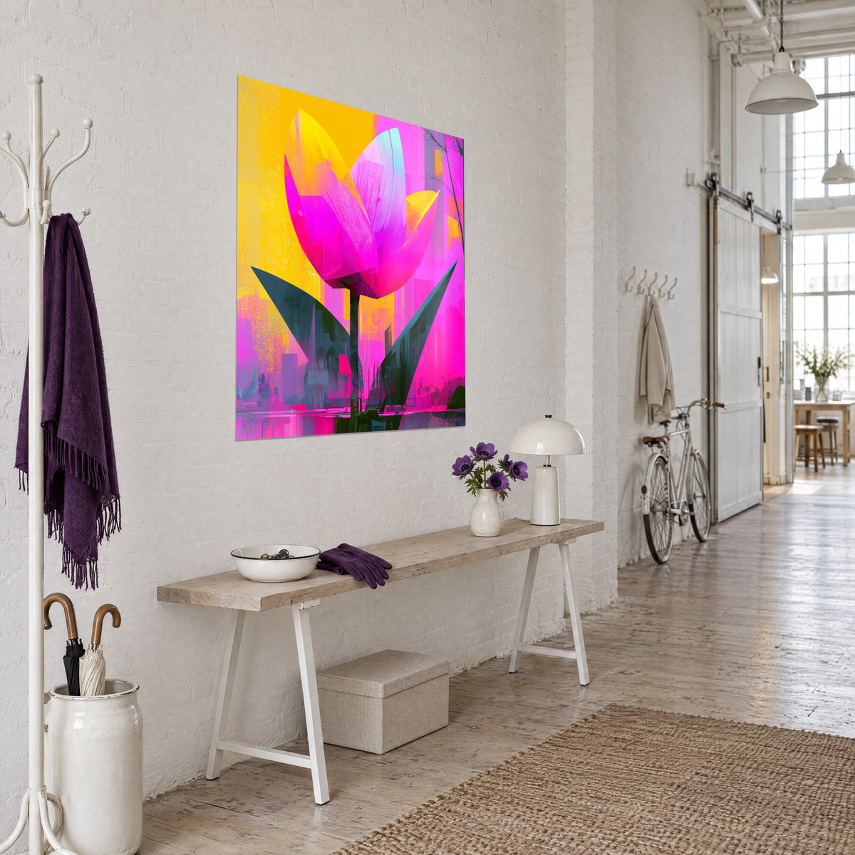 Tableau fleur aux pétales magenta et lilas, silhouettes urbaines violettes en fond, accroché près d'une console en bois, loft