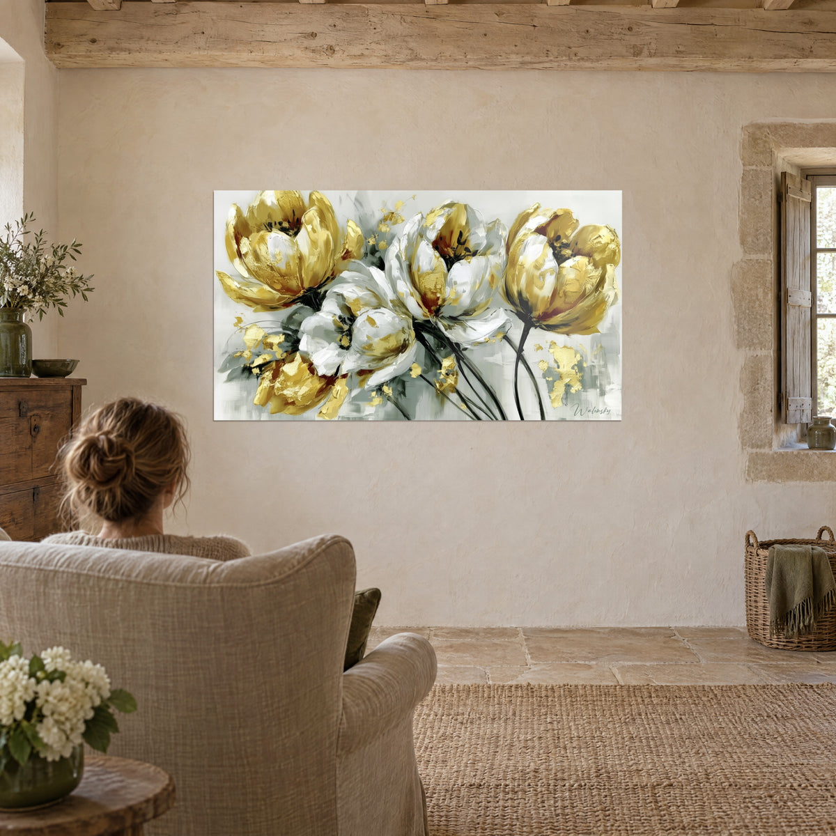 Tableau grandes tulipes feuilletées d'or et de blanc sur fond gris clair, contemplé par une femme assise dans un fauteuil en lin