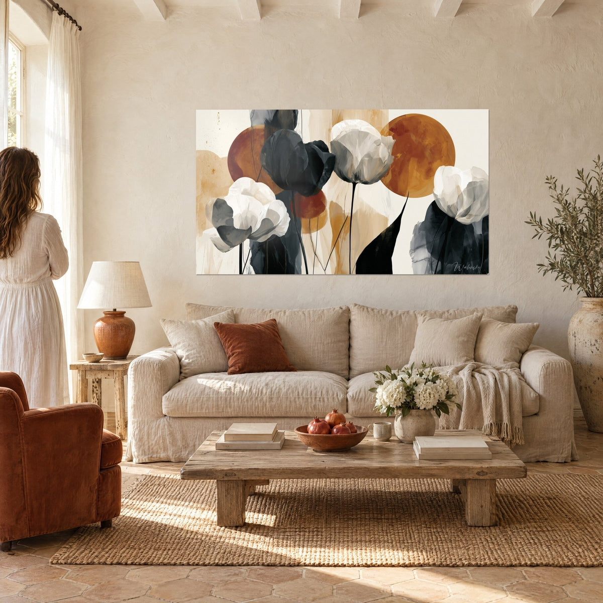 Tableau tulipes blanches et anthracite devant des disques ocre, femme de dos, au-dessus d'un canapé dans un salon lumineux