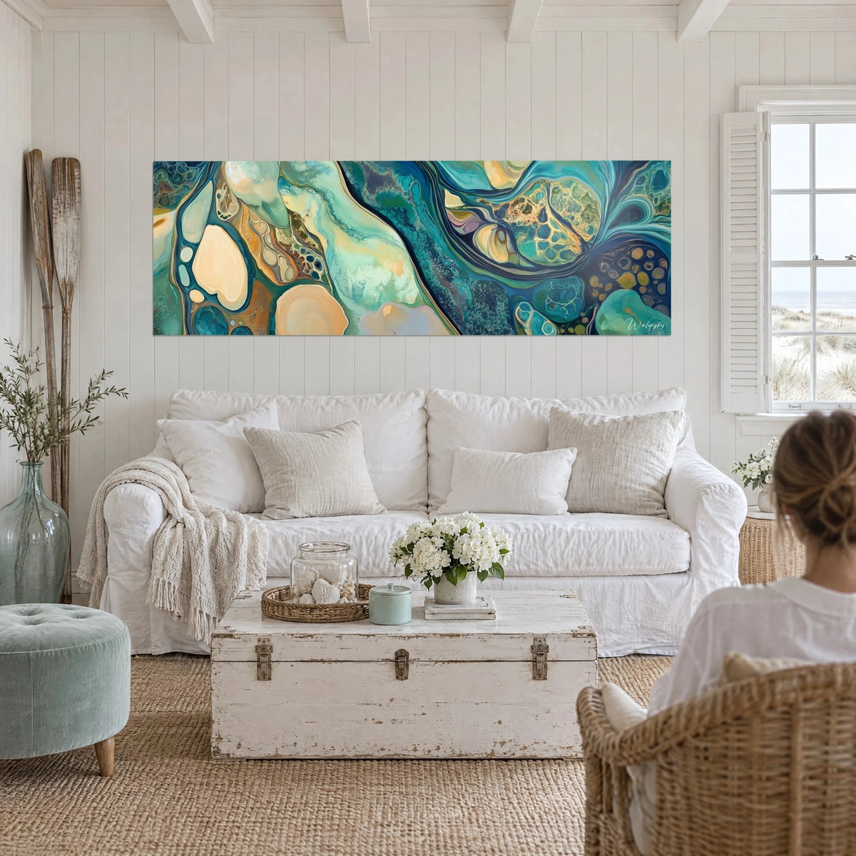 Tableau marbrure fluide turquoise et ocre sable, cellules rondes cernées d'or, au-dessus d'un canapé dans un salon lumineux