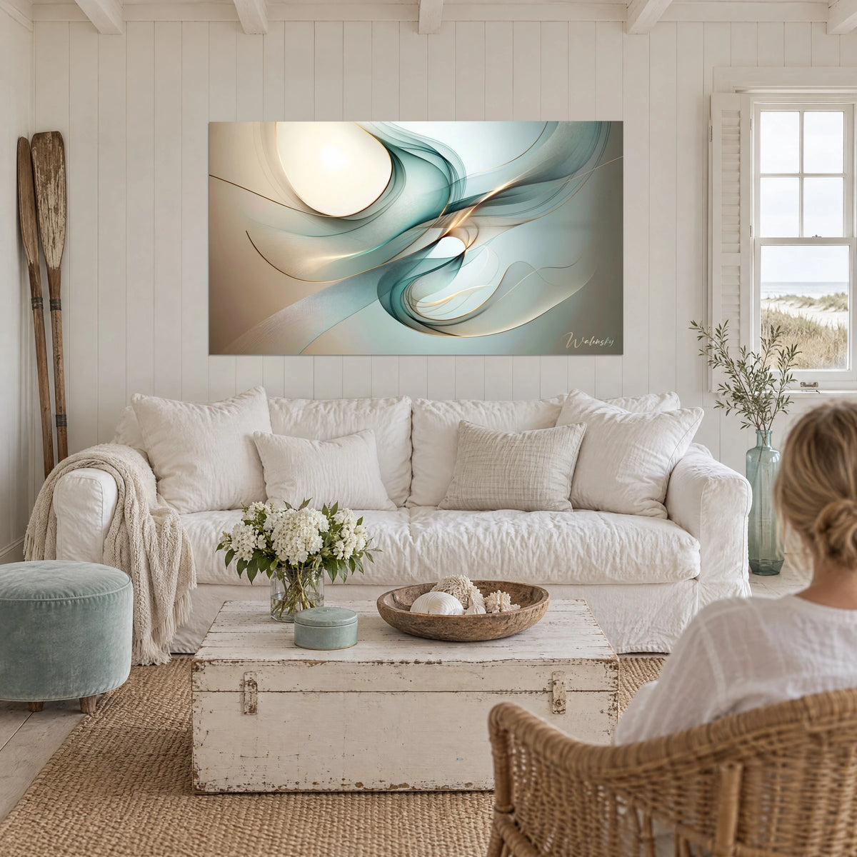 Wall art of turquoise silk veils and gold lines swirling around an ivory disc, above a sofa in a bright living room