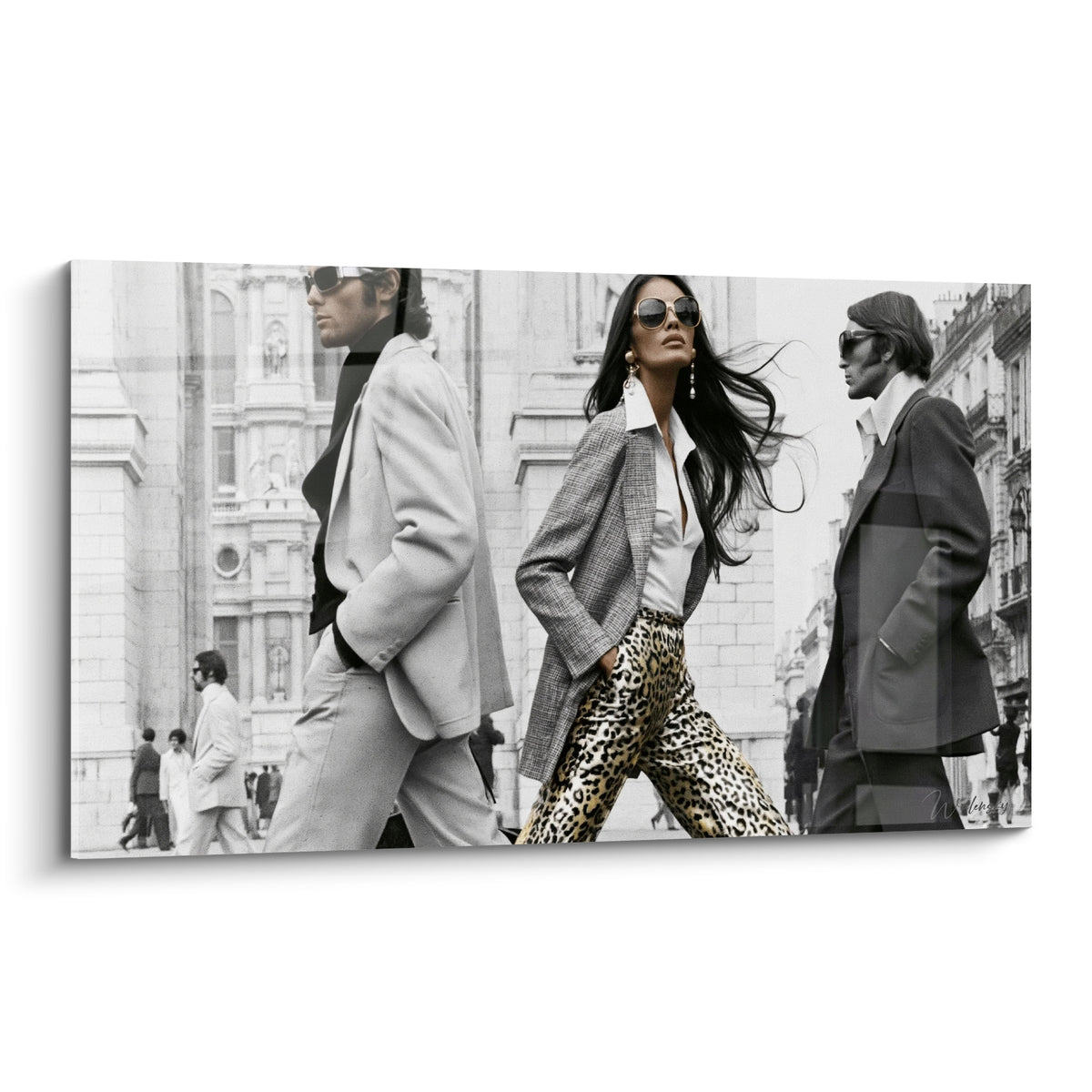 Femme brune en blazer gris et pantalon léopard doré traverse une rue en noir et blanc