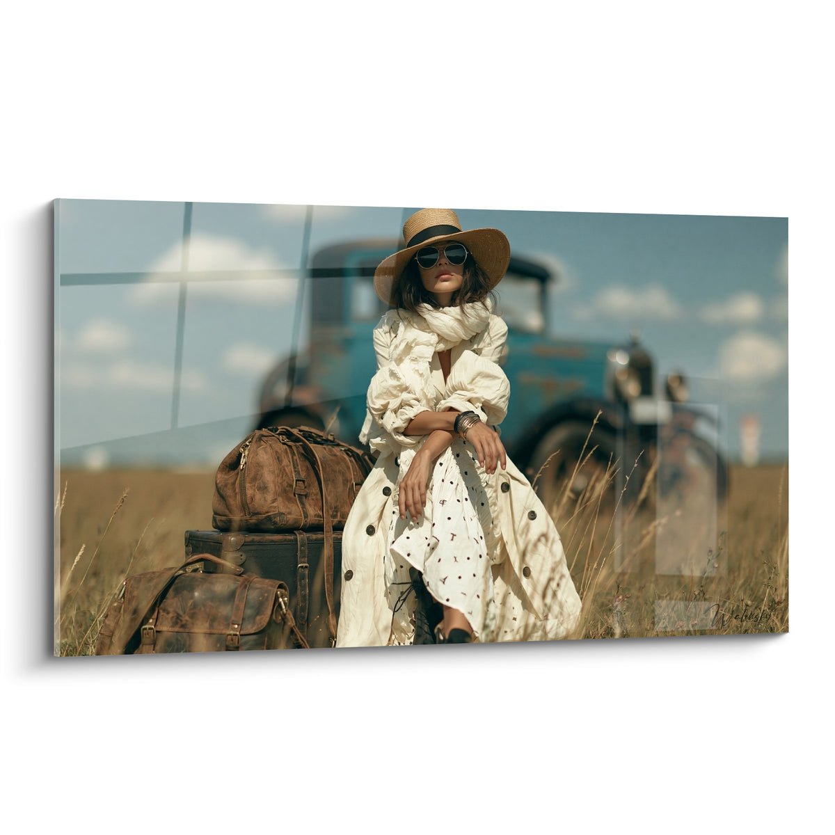 Voyageuse en robe blanche et chapeau paille assise près de valises en cuir marron