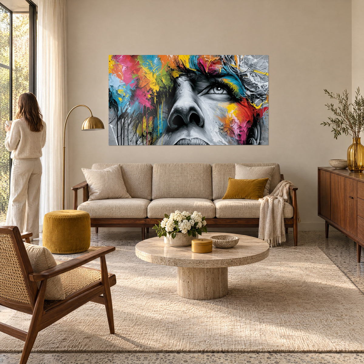 Wall art black and white portrait splashed with yellow and pink, a woman seen from behind above a sofa in a bright living room