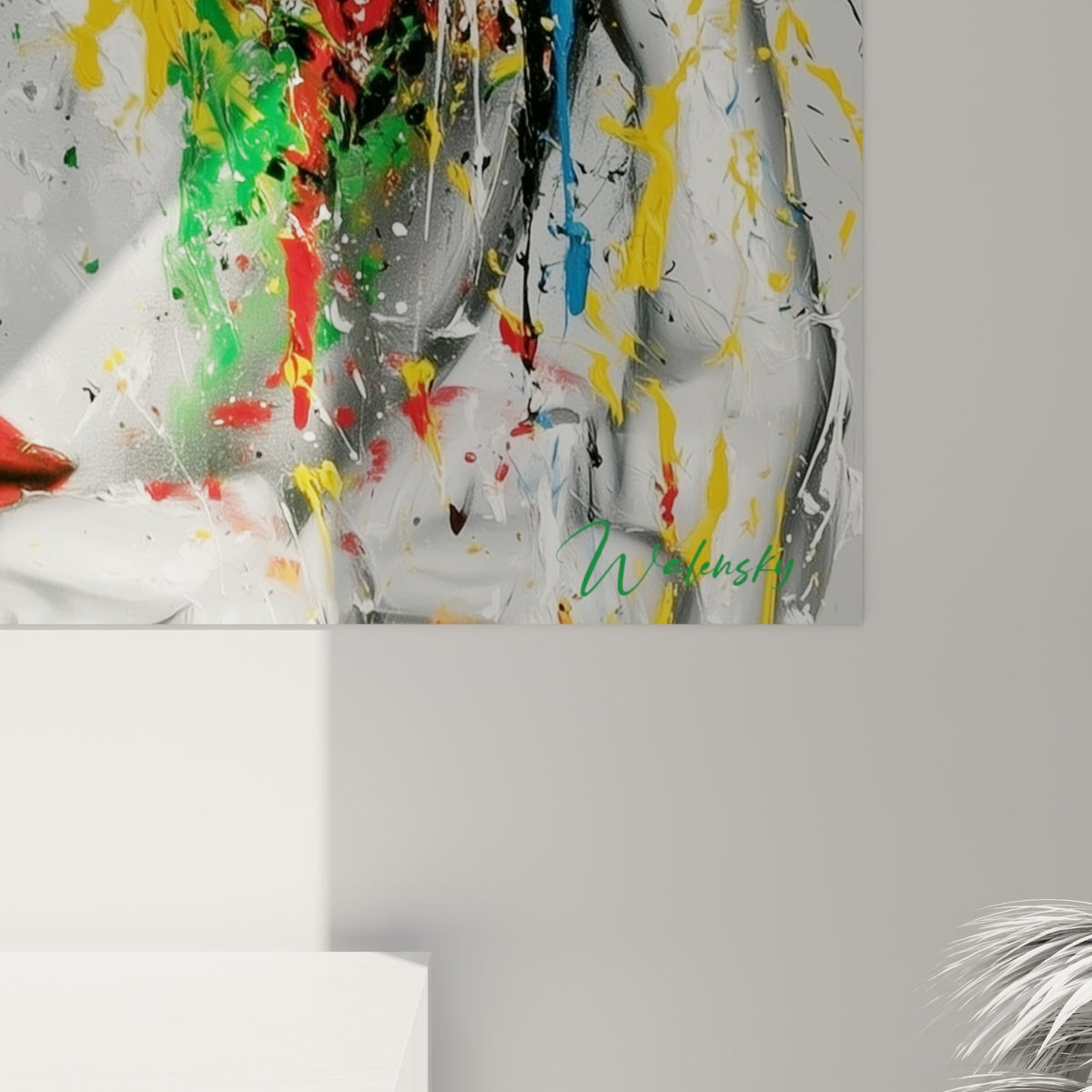 Empâtements de peinture rouge et jaune se mêlant sur le grain du visage abstrait accroché au mur