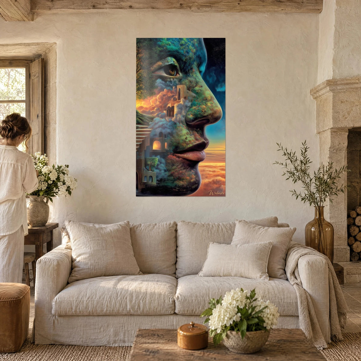 Gemälde Profil eines Gesichts aus grünem Moos und ockerfarbenen Ruinen, orangefarbener Himmel, an einer Steinwand über einem Sofa in einem hellen Wohnzimmer
