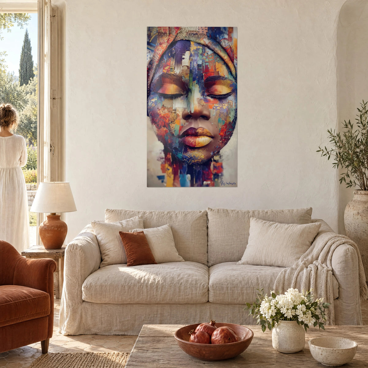 Quadro volto africano con palpebre chiuse, frammenti blu cobalto e arancio bruciato, labbra dorate, sopra un divano in un soggiorno luminoso