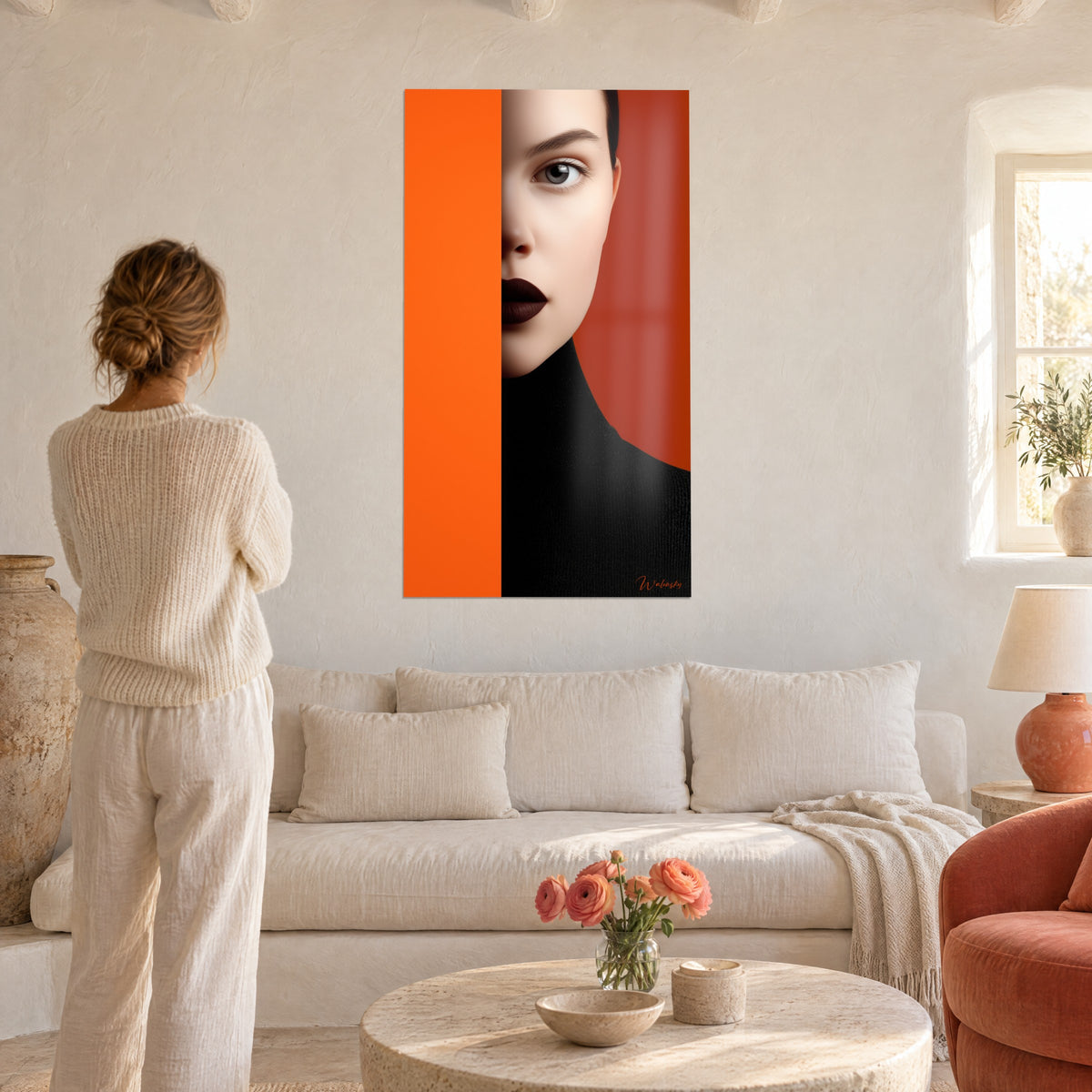Cuadro retrato de medio rostro tras un fondo naranja vivo, labios marrones, cuello alto negro, sobre un sofá en un salón luminoso