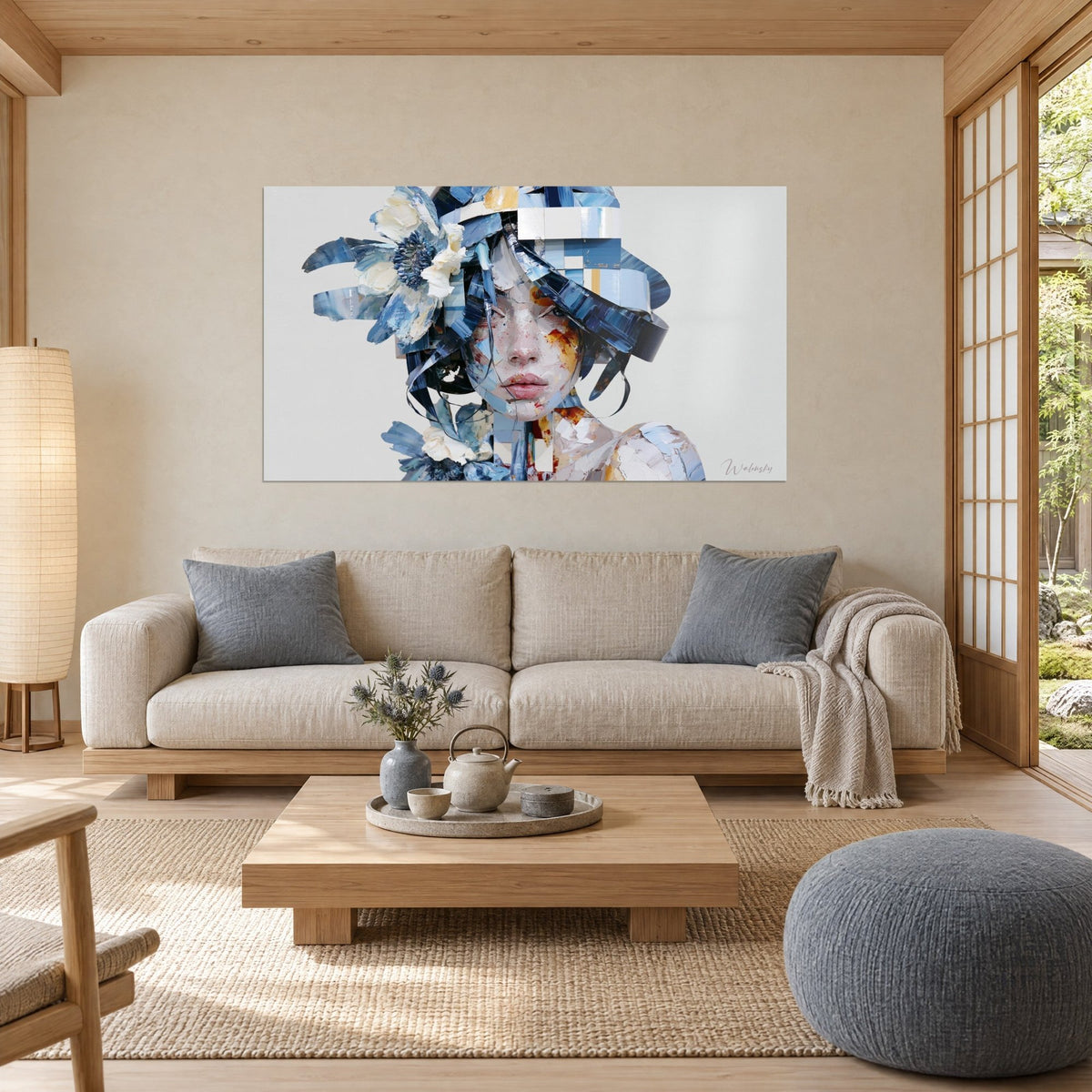 Gemälde Frauengesicht in Fragmenten aus Marineblau und Weiß, cremefarbene Blüte an der Schläfe, über einem Sofa in einem hellen Wohnzimmer