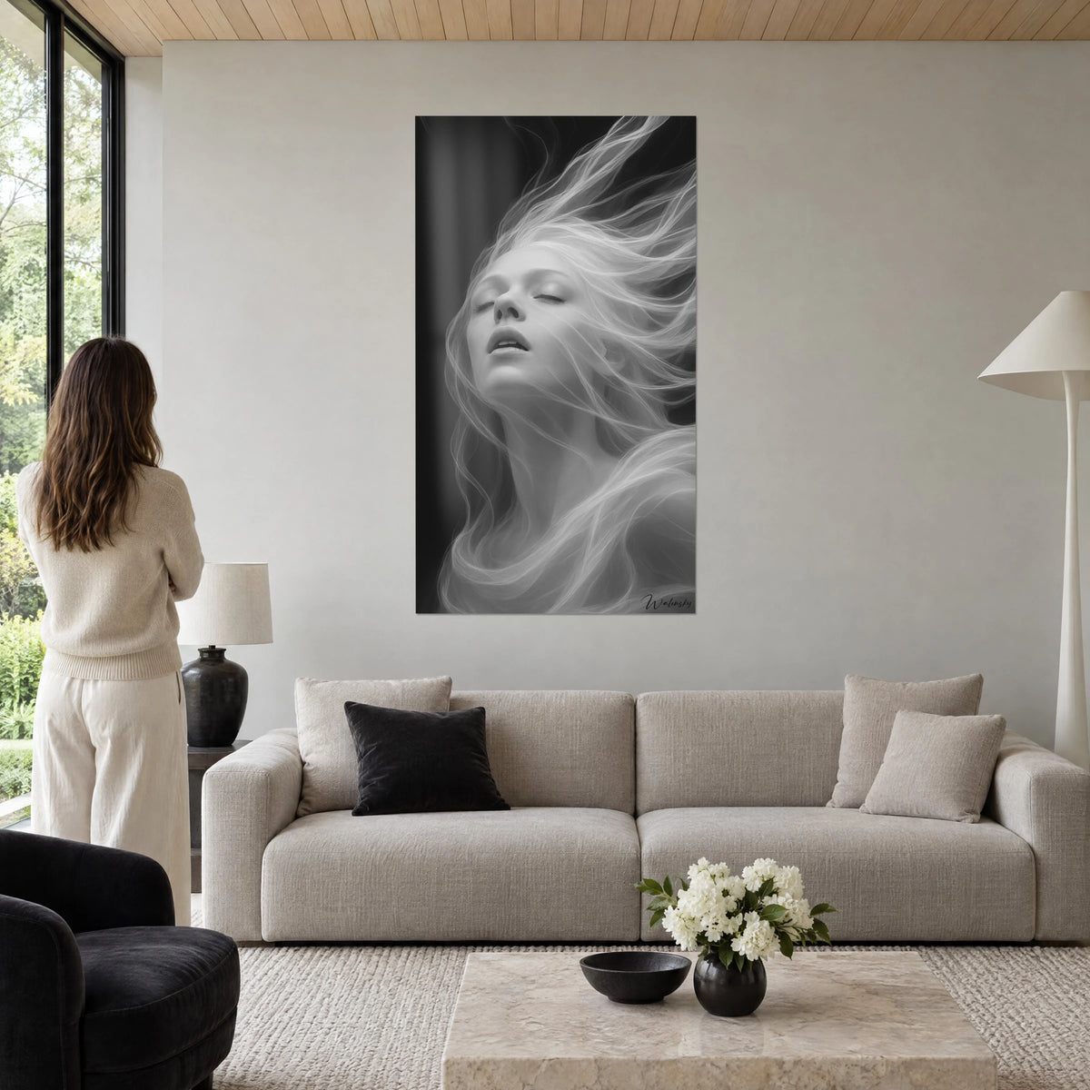 Cuadro retrato femenino de cabello blanco como humo sobre fondo negro, rostro invertido, encima de un sofá en un salón luminoso