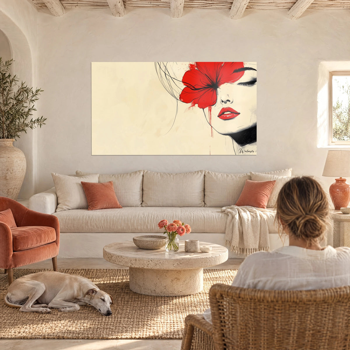 Cuadro rostro de mujer con flor roja sobre fondo crema, labios escarlata, encima de un sofá en un salón luminoso