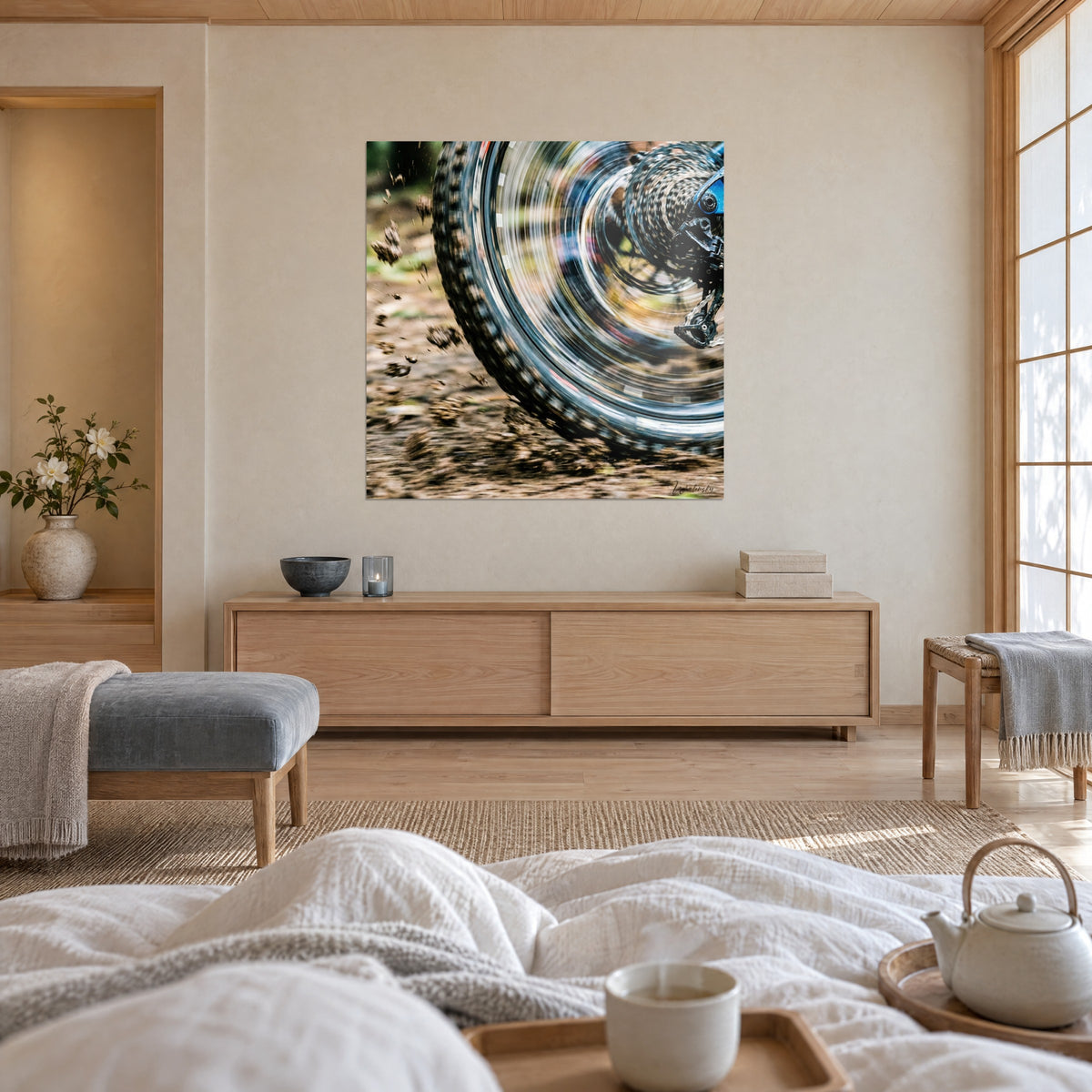 Wall art of a spinning rim and carved tire tread, metallic grey and earthy brown tones, above a bed in a light bedroom