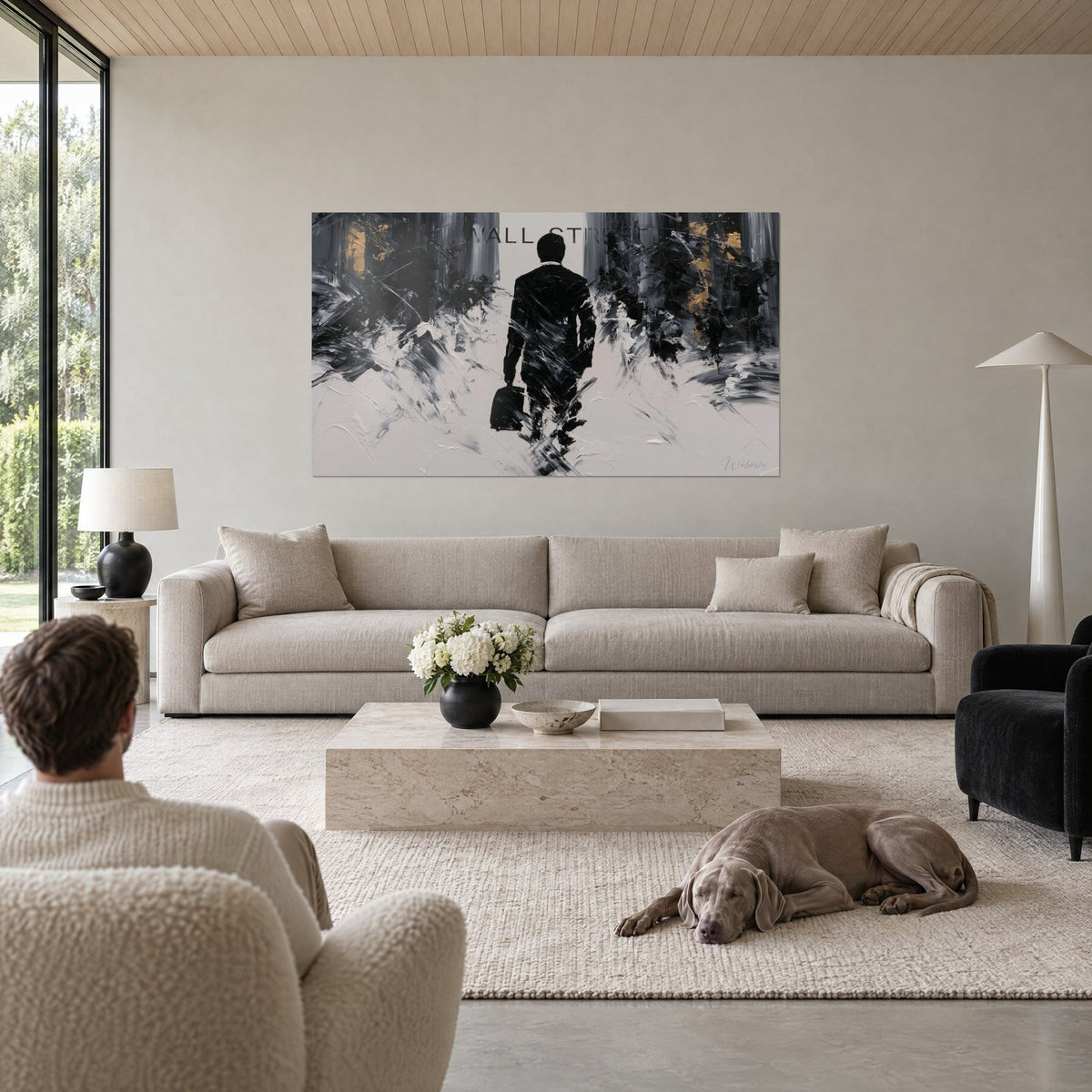 Wall art silhouette of a businessman seen from behind with black, grey and ochre-gold palette-knife strokes, hanging above a sofa in a bright living room