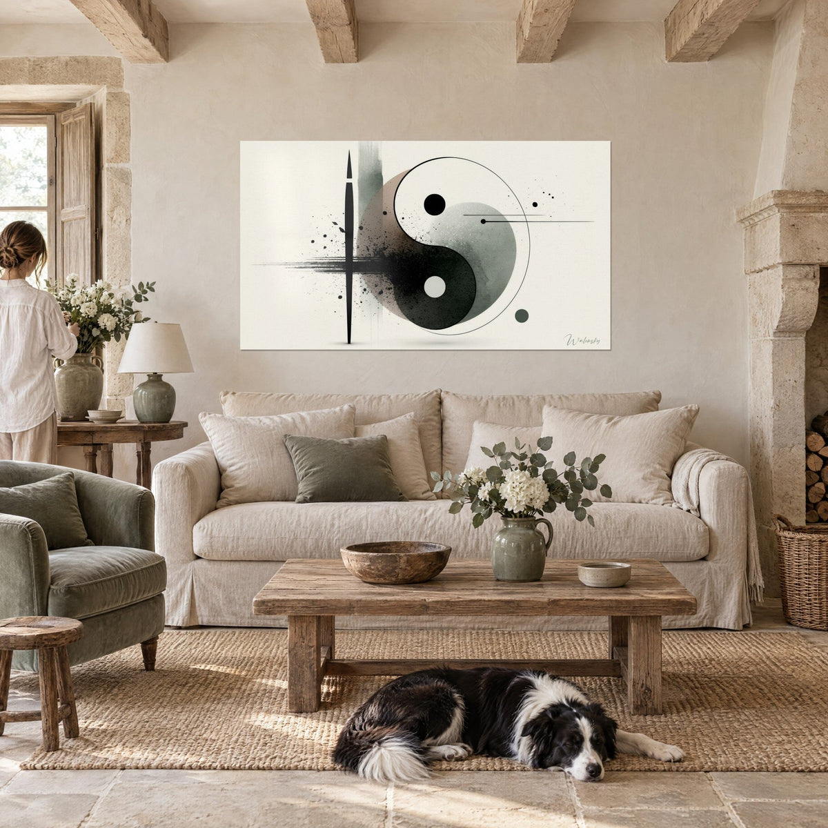 Schilderij yin yang in zwarte inkt en saliegroen, donkere spatten, vrouw van achteren en collie, boven een bank in een lichte woonkamer