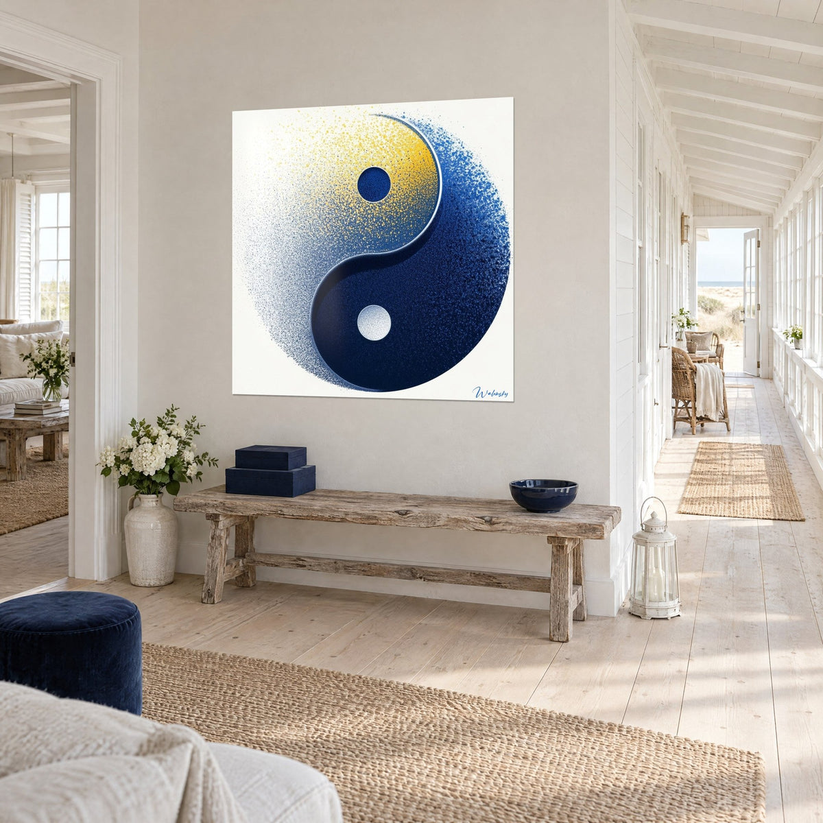Wall art balance symbol in dotted saffron yellow and midnight blue, seen at an angle in a hallway above a wooden bench and a white vase
