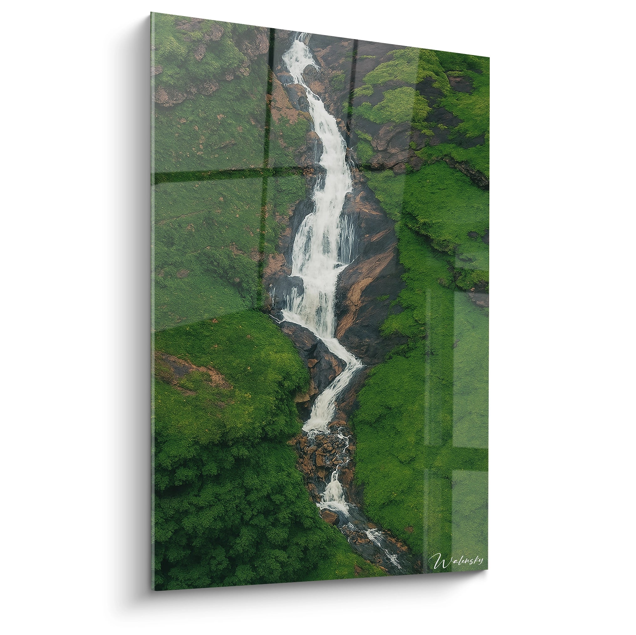 Un tableau artistique représentant une cascade vue aérienne serpentant entre des falaises verdoyantes, avec des eaux blanches contrastant avec la verdure luxuriante et les roches brunes, offrant une perspective plongeante saisissante.