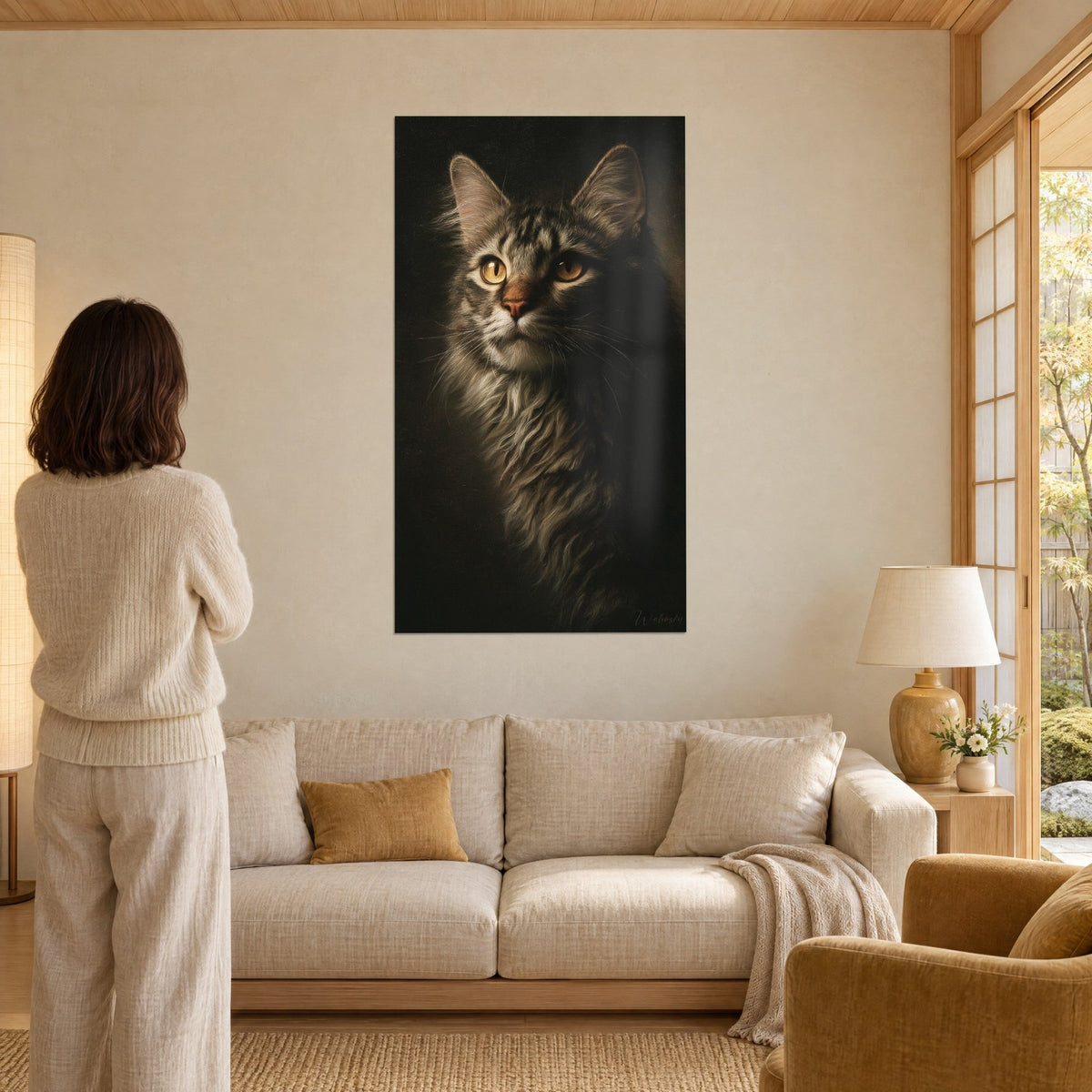 Tableau portrait de chat tigré aux yeux ambre, fourrure grise et noire sur fond sombre, au-dessus d'un canapé dans un salon lumineux