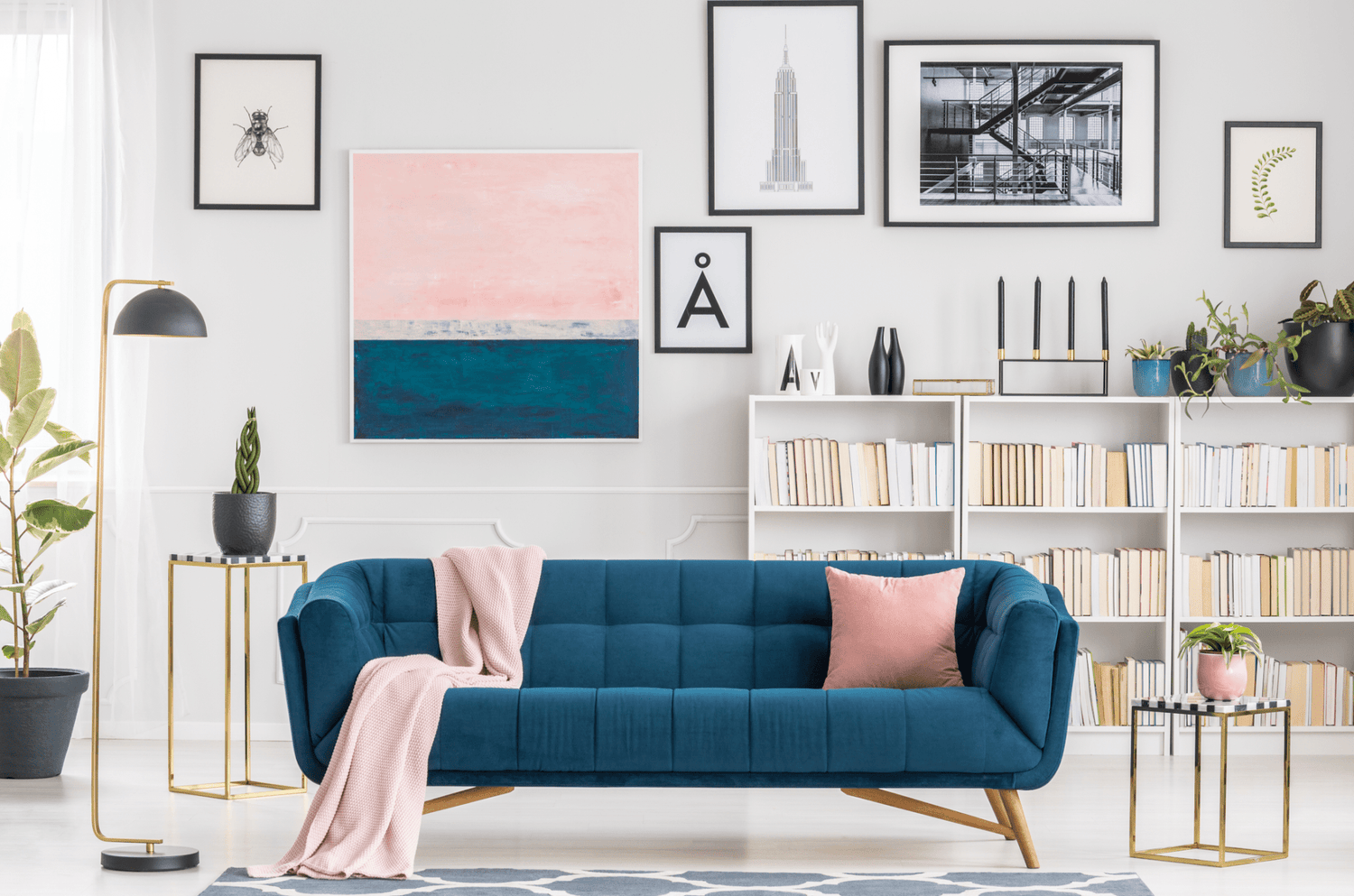 Canapé bleu moderne dans un salon décoré avec des livres et des œuvres d'art murales