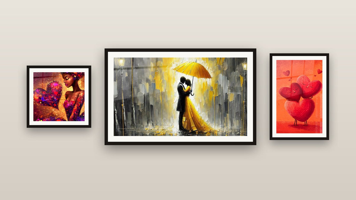 Pared de galería con tres cuadros enmarcados: Mujer Corazón Apasionado, Corazón Enlace Indefectible y Amor Bajo la Lluvia