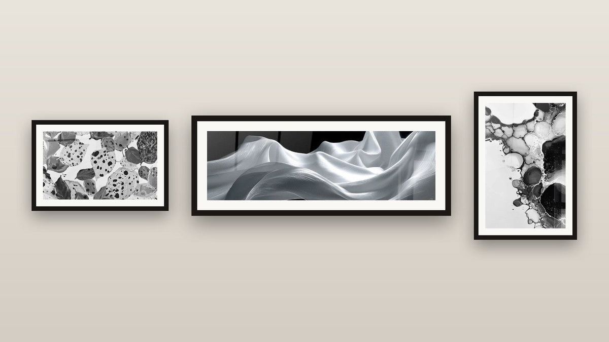 Pared de galería con tres cuadros enmarcados: Explosiones Orgánicas, Burbujas abstractas y Olas Fluidas