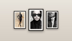 Pared de galería con tres cuadros enmarcados: Estilo Años 40, Mujer con Hiyab y Silueta negra y beige con cintas escarlata