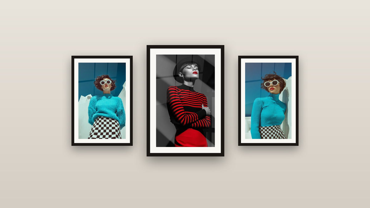 Mur de galerie avec trois tableaux encadrés, dont Chapeau noir et jupe rouge yeux clos