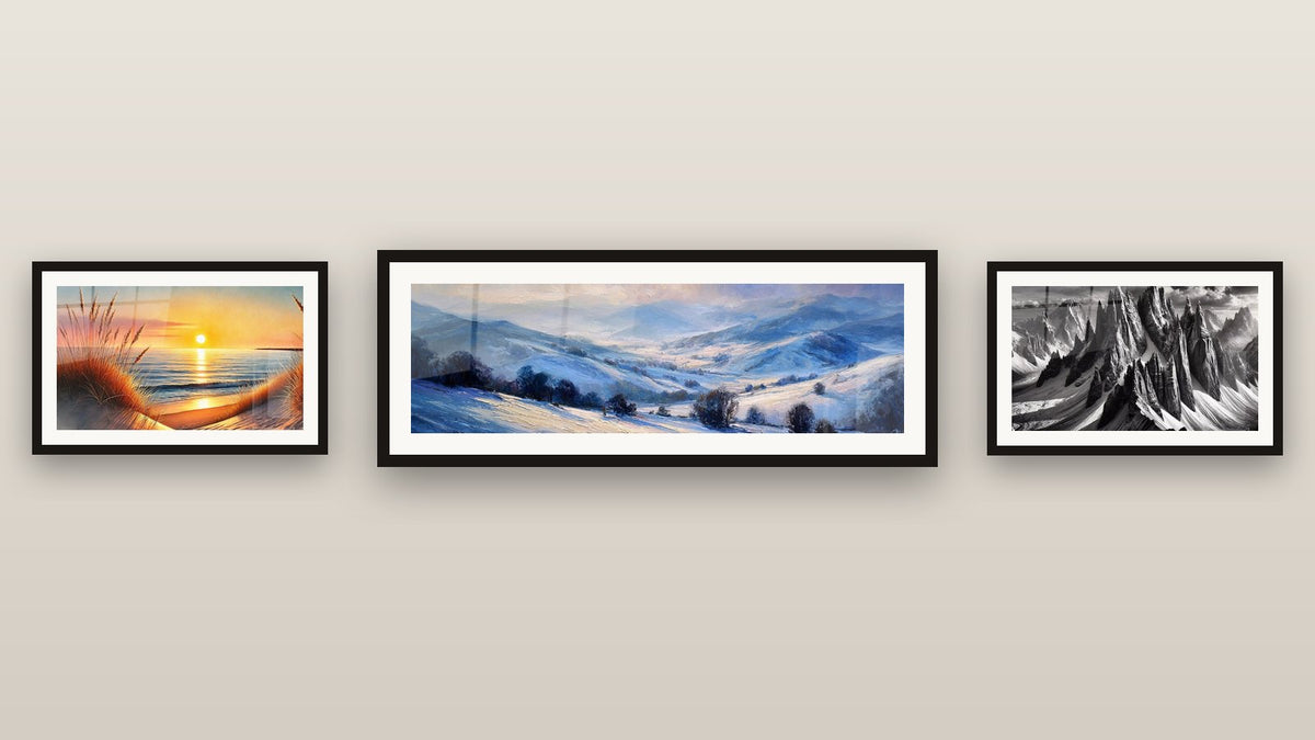 Mur de galerie avec trois tableaux encadrés : Paysage montagneux enneigé, Quand le Jour S’endort et À l’Ombre des Géants