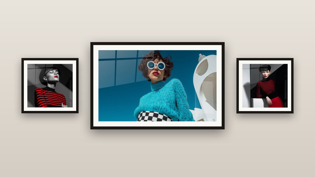 Pared de galería con tres cuadros enmarcados, entre ellos Mujer jersey turquesa gafas redondas