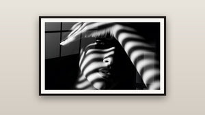 Ingelijst schilderij aan een muur: Vrouw Gestreepte Schaduwen