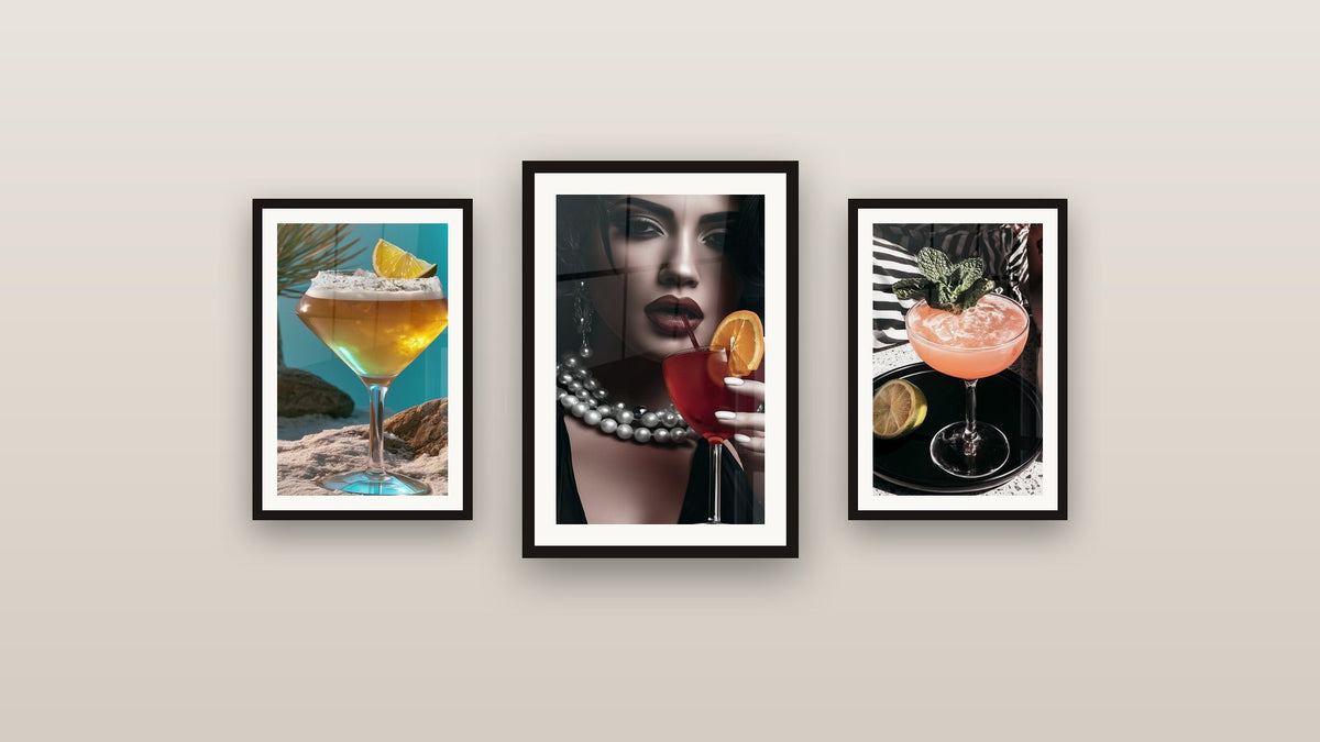 Pared de galería con tres cuadros enmarcados, entre ellos Mujer blanco y negro con cóctel rojo y Corte Dorado con Sal y Limón