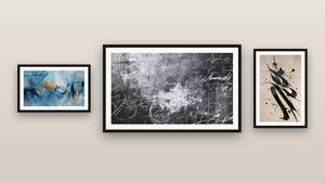 Galerijwand met drie ingelijste schilderijen, waaronder Abstracte kalligrafie en Abstracte gouden cirkellijst