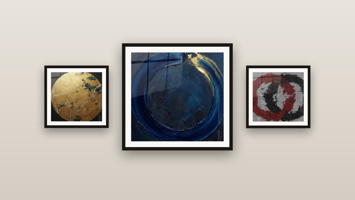 Pared de galería con tres cuadros enmarcados, entre ellos Círculo Azul Noche y Oro sobre Fondo Gris
