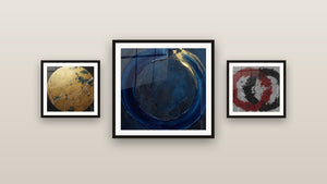 Pared de galería con tres cuadros enmarcados, entre ellos Círculo Azul Noche y Oro sobre Fondo Gris