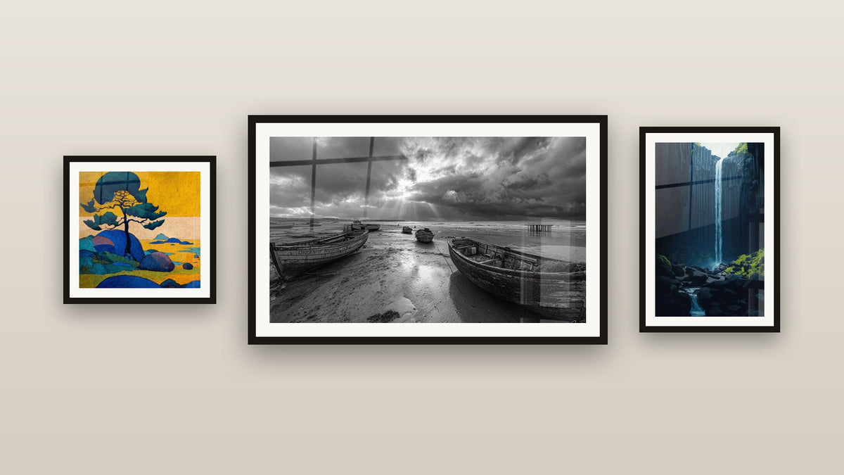 Gallery wall with three framed paintings, including Tree at Sunset and Beached Fishing Boats