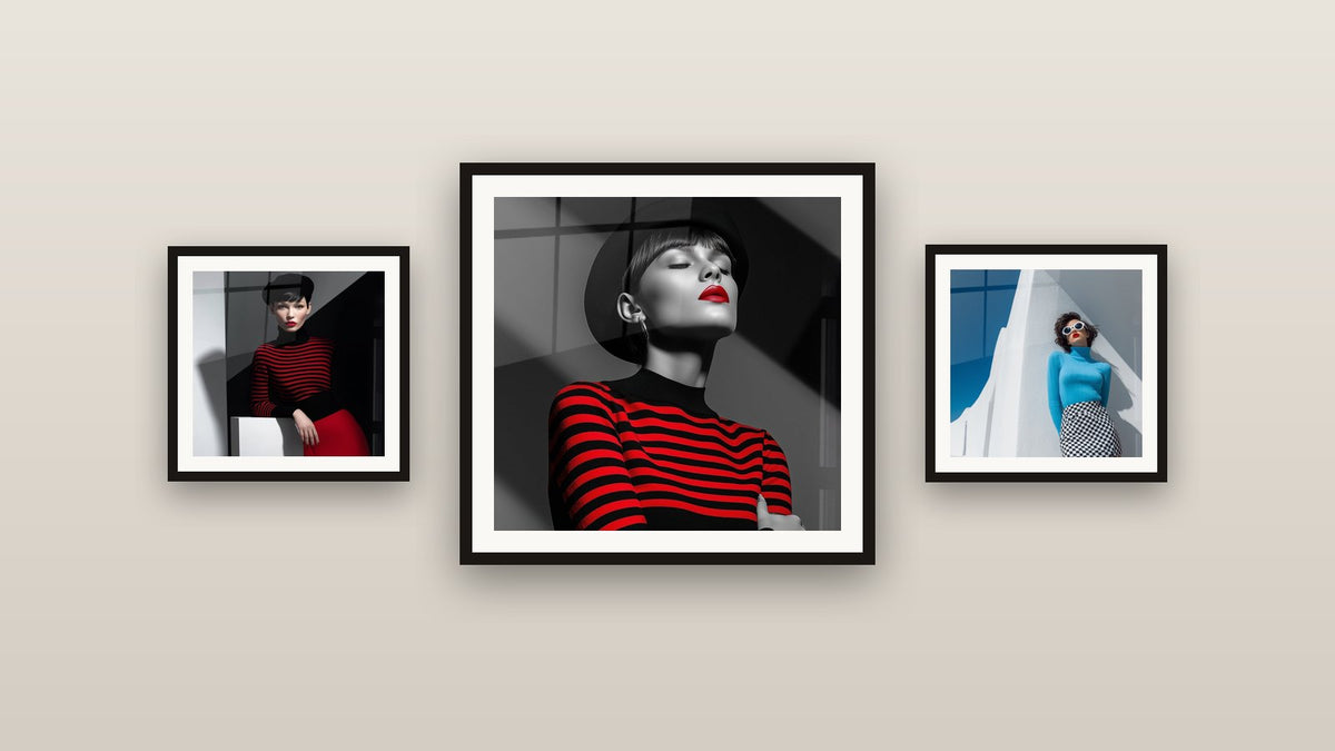 Pared de galería con tres cuadros enmarcados, entre ellos Mujer con sombrero negro y rayas rojas