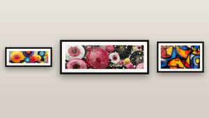 Pared de galería con tres cuadros enmarcados, entre ellos Círculos rosas y dorados estallados y Formas geométricas coloridas