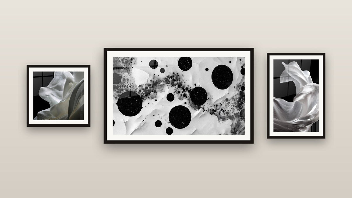Pared de galería con tres cuadros enmarcados: Estrellas Dispersas, Tela blanca fluido y Telas Fluidas