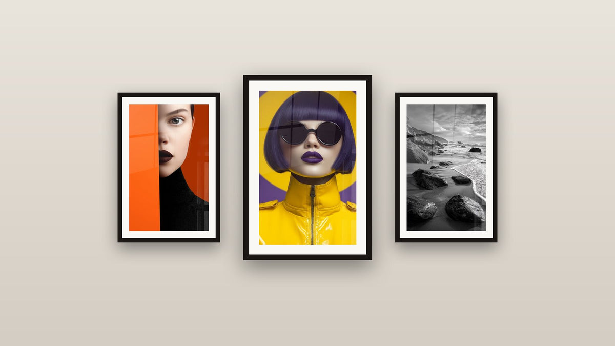 Mur de galerie avec trois tableaux encadrés, dont Plage aux Rochers et Portrait visage orange et noir