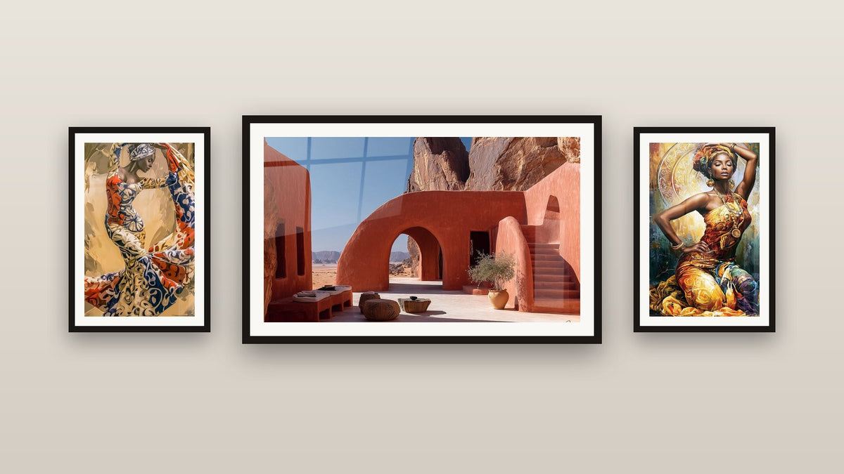 Parete galleria con tre quadri incorniciati, tra cui Architettura del Deserto e Ballerina in abito wax blu e terracotta
