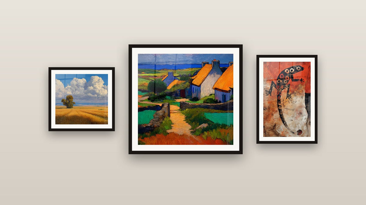 Pared de galería con tres cuadros enmarcados: Paisaje rural, Pueblo costero y Lagarto estilizado