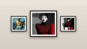 Gallery wall with three framed paintings, including Man in Yellow Shirt Among Blue Hydrangeas