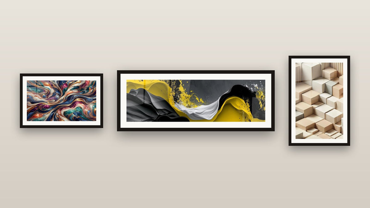 Pared de galería con tres cuadros enmarcados: Cosmos Encantado, Olas fluidas amarillas y negras y Minimalismo Esculpido