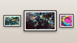 Pared de galería con tres cuadros enmarcados: Espiral multicolor, Mapa del Mundo N°2 y Mapa del Mundo N°1