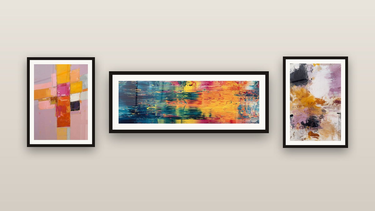 Mur de galerie avec trois tableaux encadrés, dont Abstrait reflets colorés