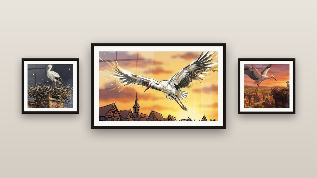 Mur de galerie avec trois tableaux encadrés : Cigogne Alsacienne, Cigogne sur Cheminée et Cigognes Village Alsacien