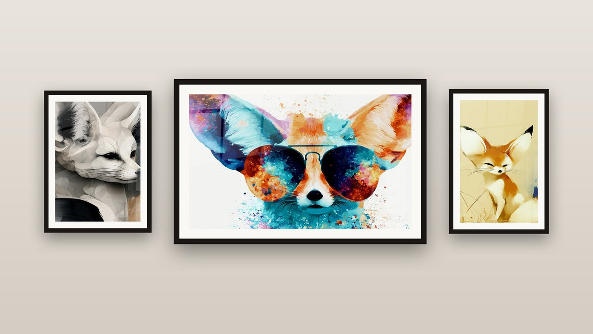 Mur de galerie avec trois tableaux encadrés, dont Fennec sable et blanc yeux fermés et Fennec ocre et turquoise à lunettes