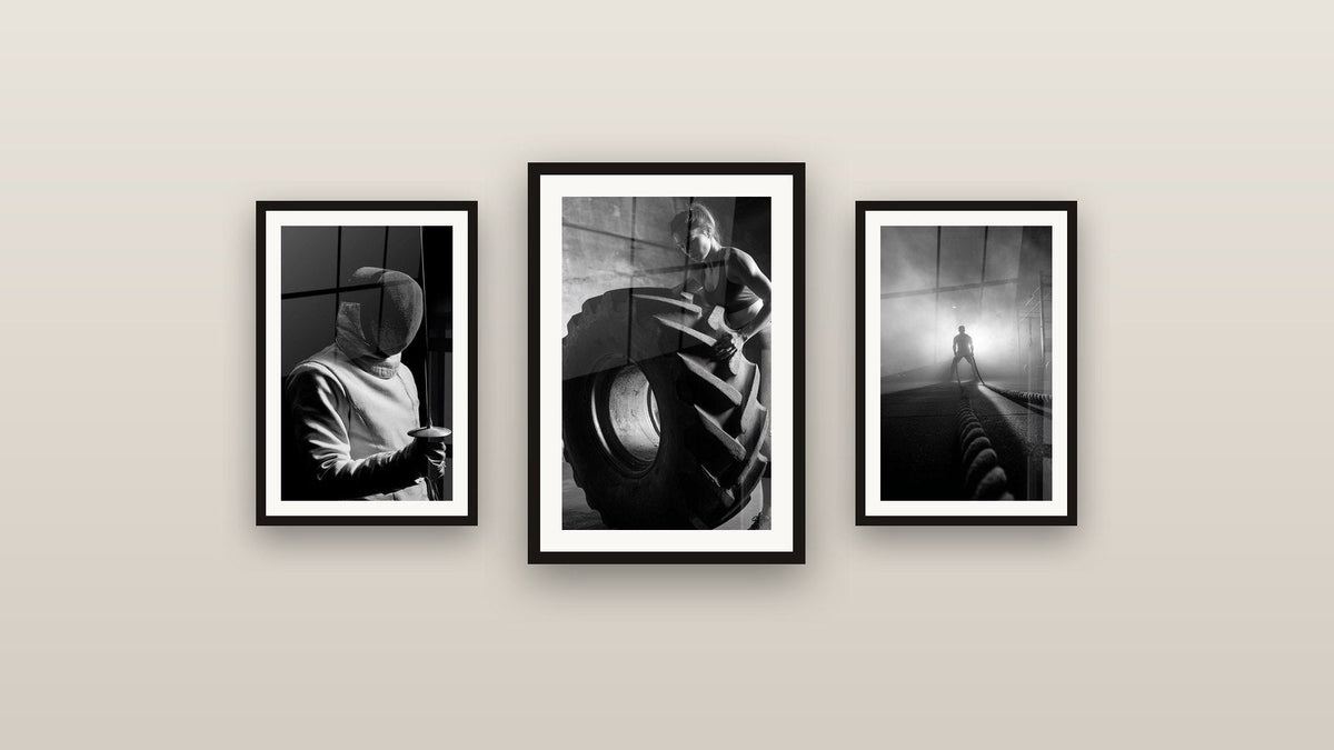 Mur de galerie avec trois tableaux encadrés : Femme Tire Pneu, Escrime et Fitness Corde d'Entraînement