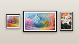 Pared de galería con tres cuadros enmarcados: Montaña nevada con árboles coloridos, Dos árboles otoño y Lirio N°2