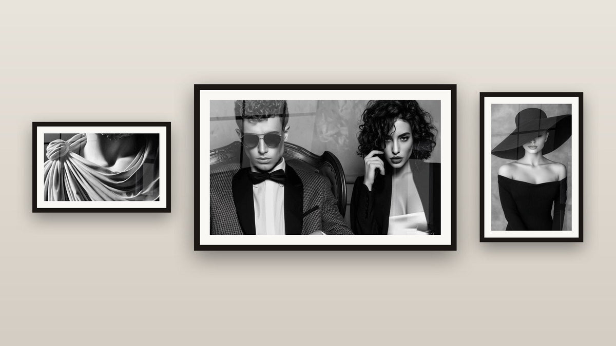 Pared de galería con tres cuadros enmarcados, entre ellos Moda blanco y negro y Mármol y fluidez